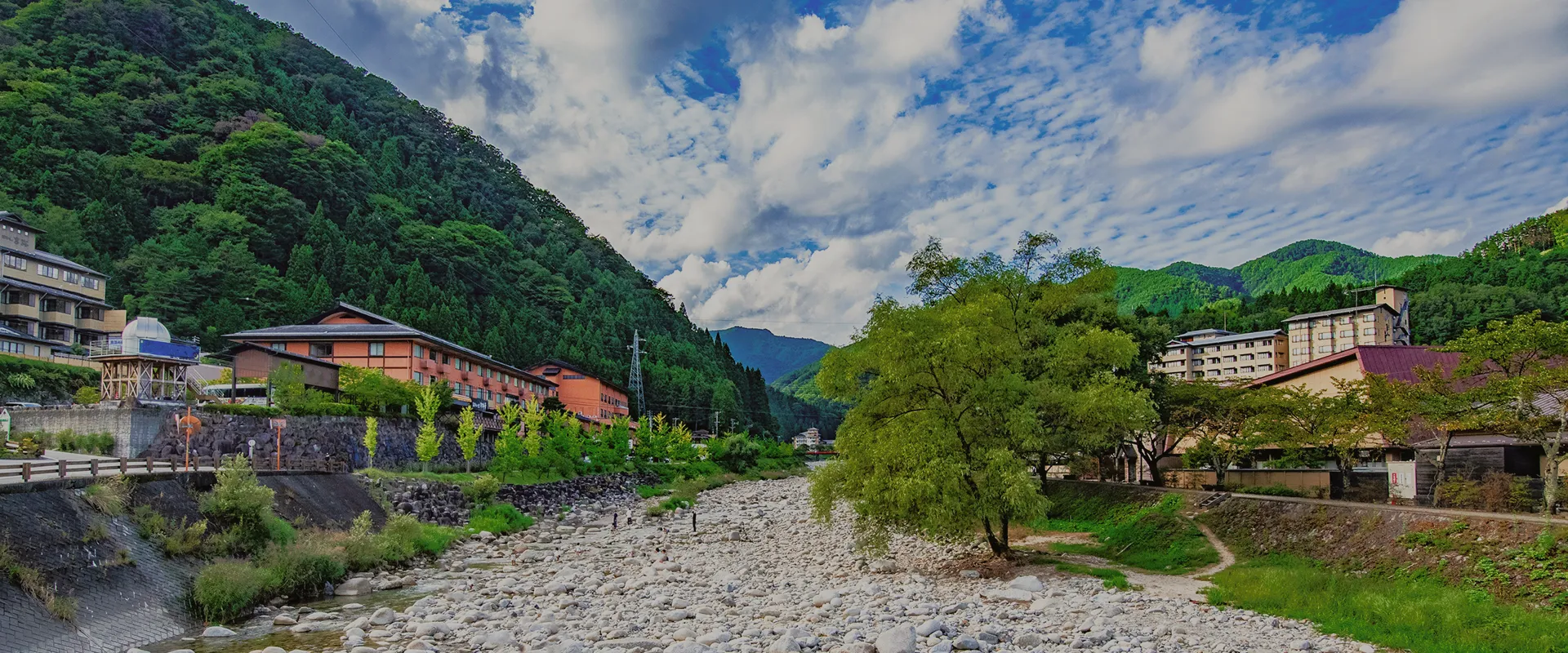 イメージ：山あいに位置する温泉街の風景。