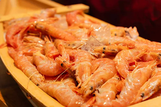木製の船盛りに氷と一緒に盛り付けられた新鮮で瑞々しい甘エビ。