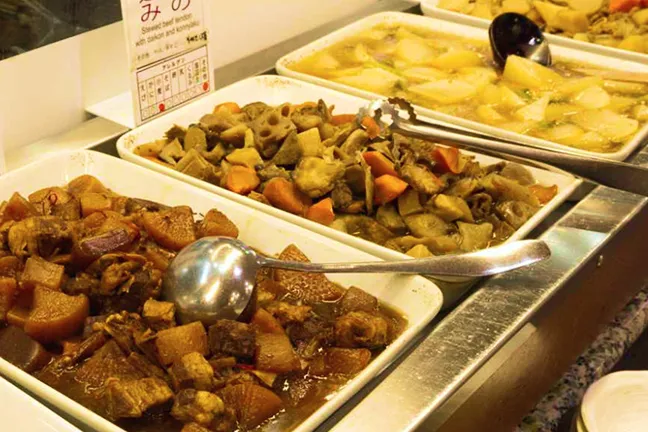 ビュッフェのトレイに並べられた、煮物など野菜をたっぷり使った日替わりのお惣菜。