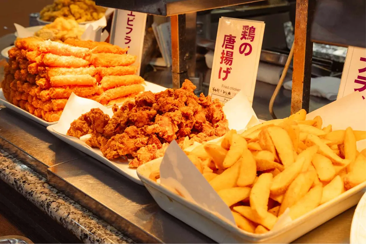 バイキングカウンターに並ぶ、揚げたてのエビフライ、鶏の唐揚げ、フライドポテトなどの揚げ物メニュー