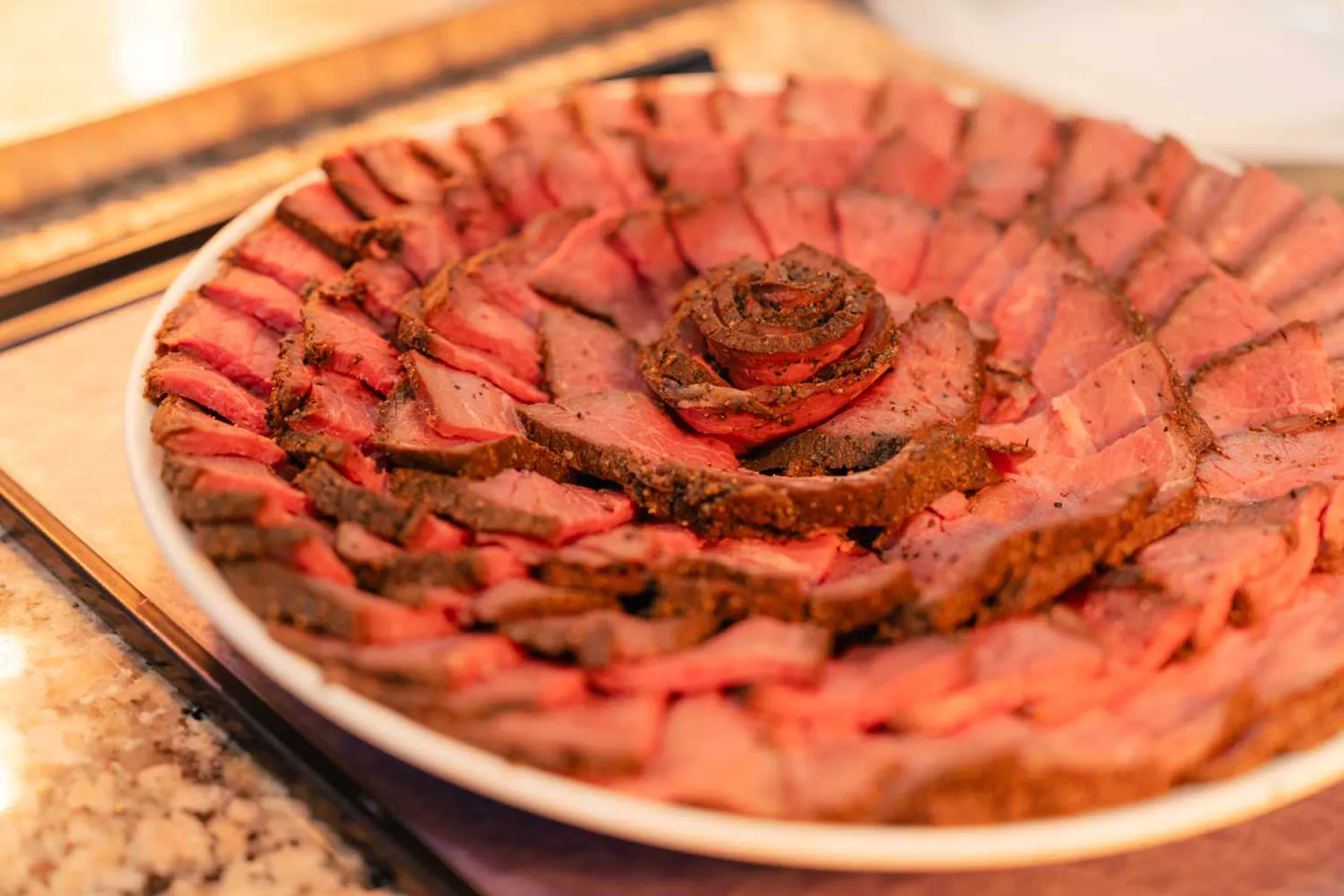 薄くスライスされたローストビーフが、お皿の上に花びらのように美しく盛り付けられています。