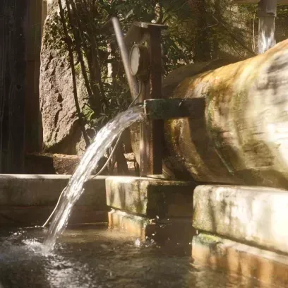 木製の湯口から勢いよく注ぎ出る、新鮮な温泉の湯。