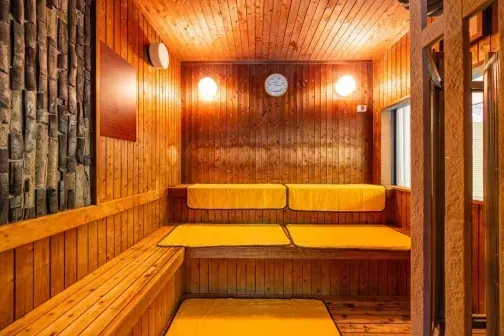 木造りで暖色照明の、座面にマットが敷かれた休憩室。