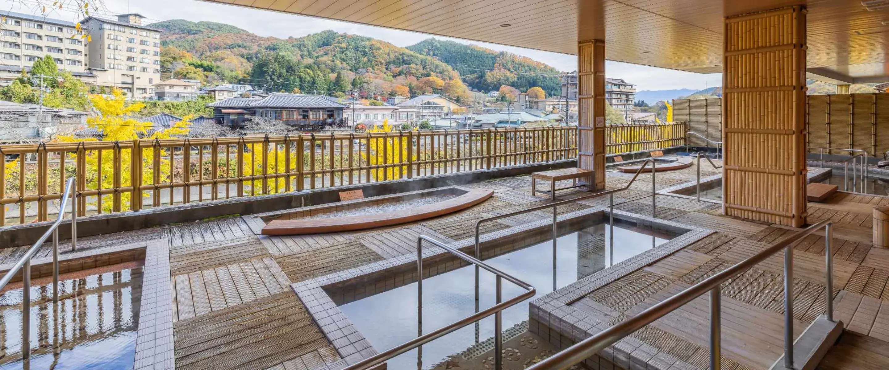 旅館のテラスにある、街並みを見下ろす露天風呂。秋の景色。