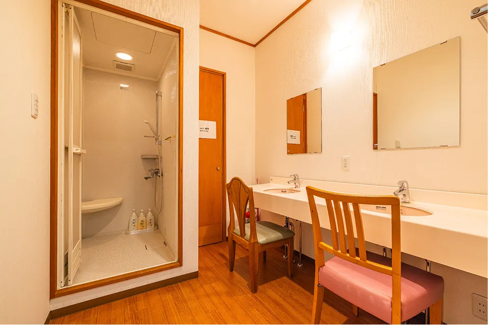 大人数での滞在に便利な、独立したシャワーブースとダブルシンクの洗面コーナー。椅子に座って身支度ができる広々としたパウダースペースには、大きな鏡が2枚設置されています。