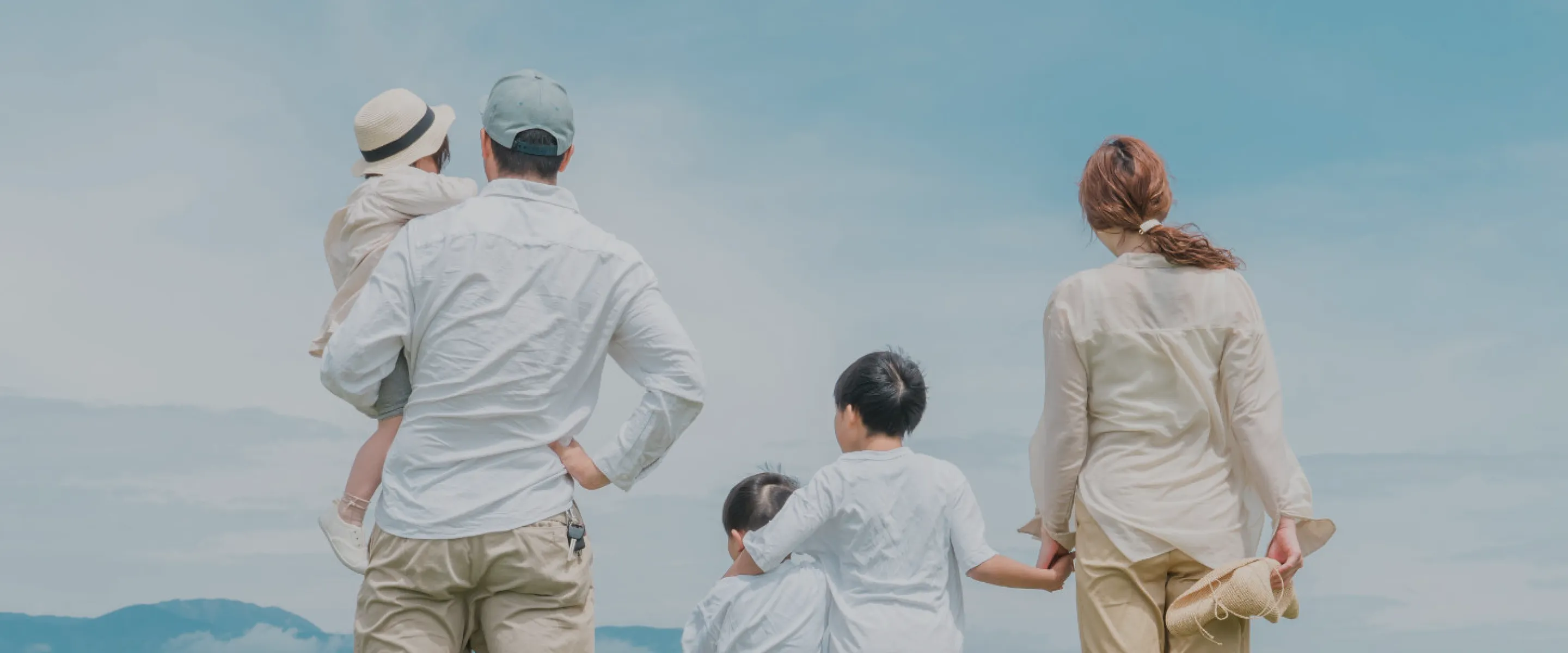 イメージ：青空の下で景色を眺める家族