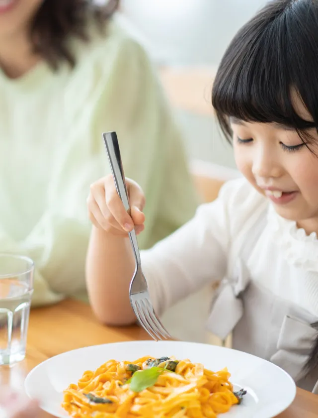 楽しそうに食事をする家族と女の子